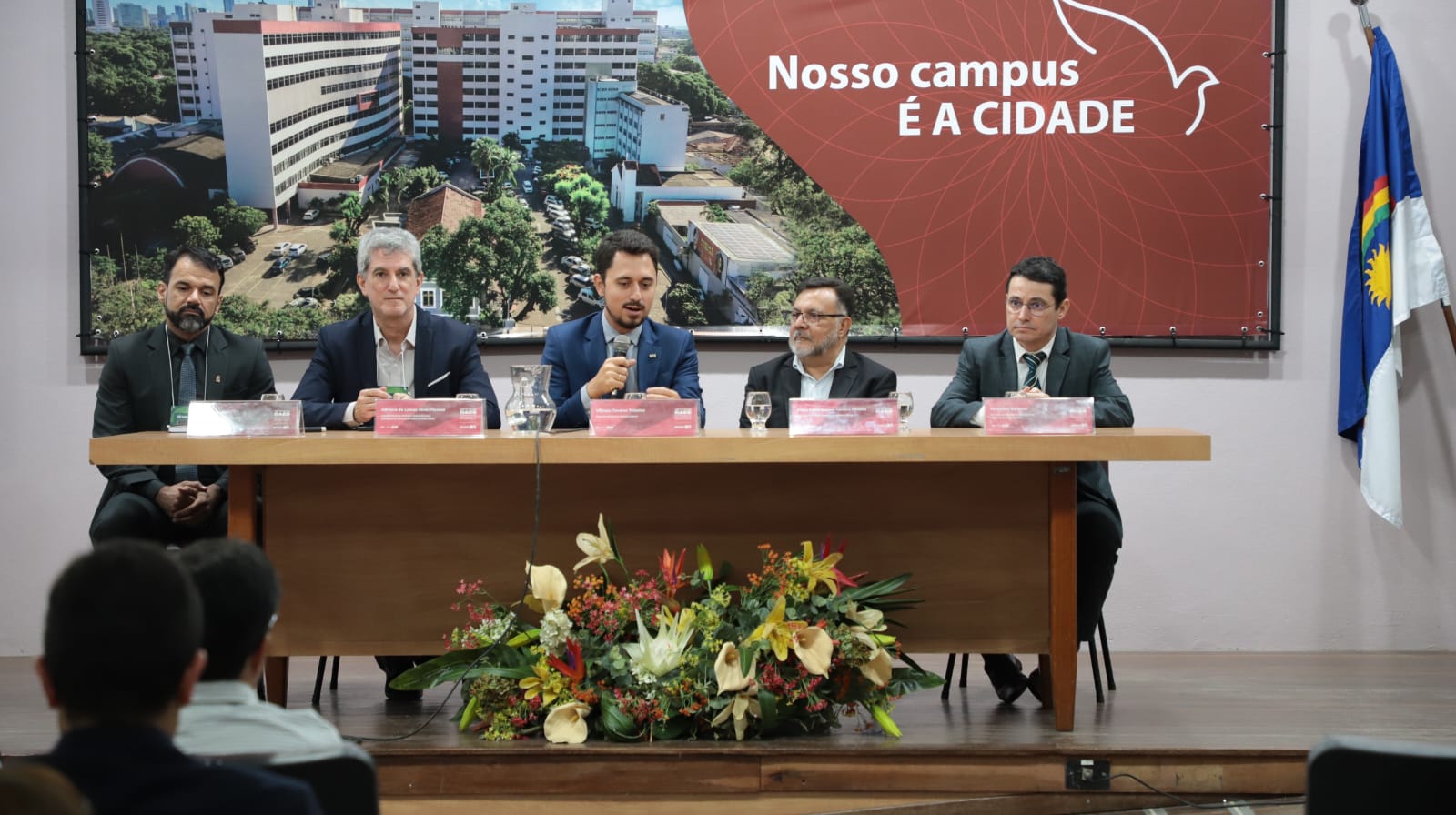 Reitor na mesa com participantes