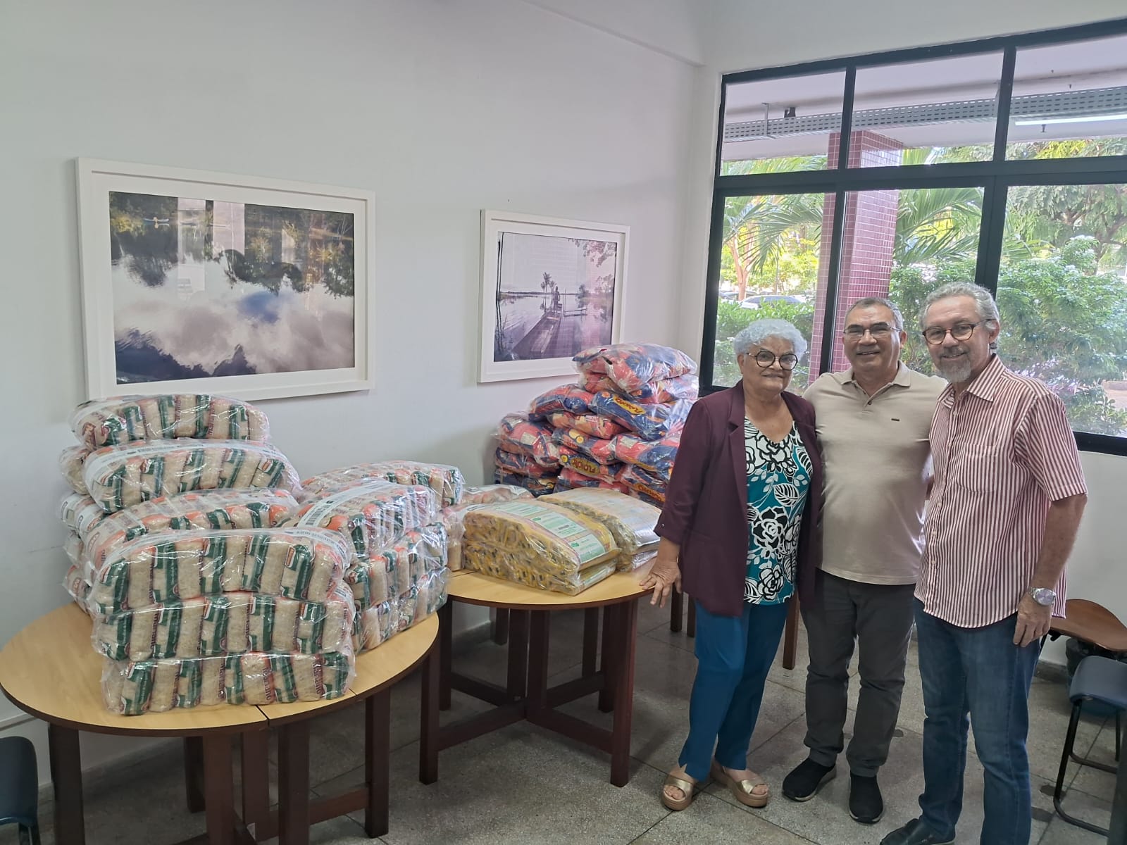 FOTO DE 03 PESSOAS E DOS ALIMENTOS ARRECADADOS