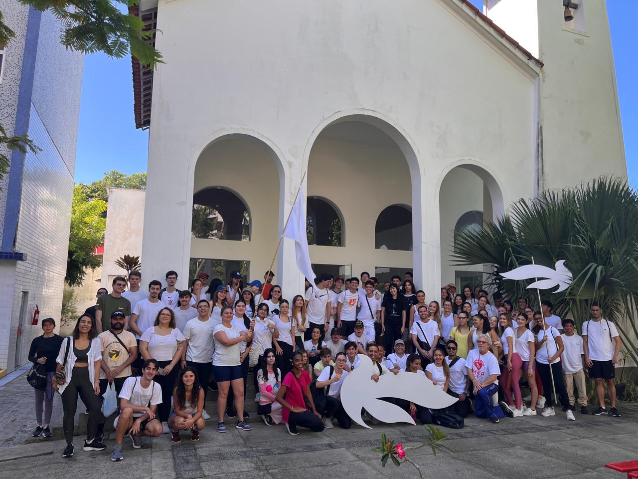 Grupo de lalunos e alunas na frente da Capela  do campus da Unicap