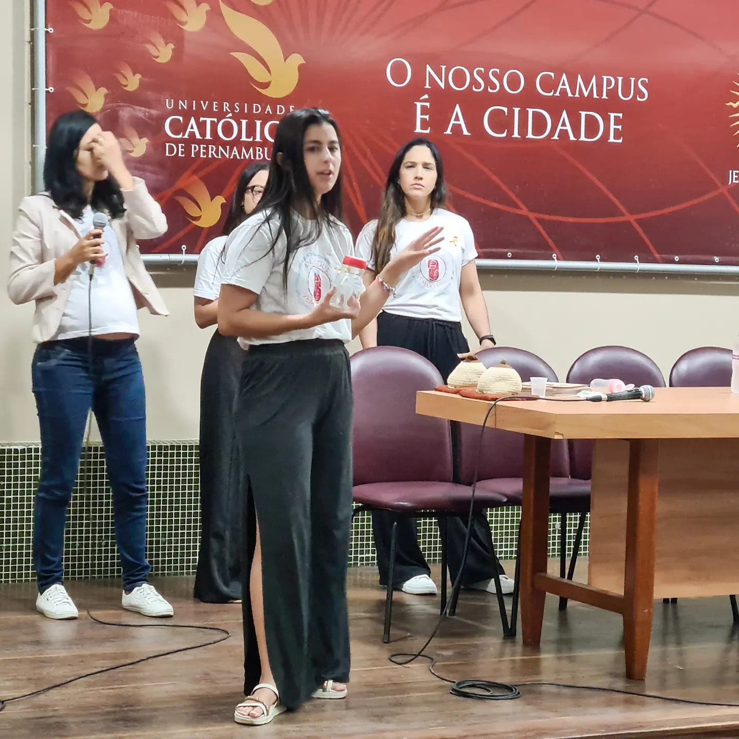 Quatro alunas apresentando o tema do evento