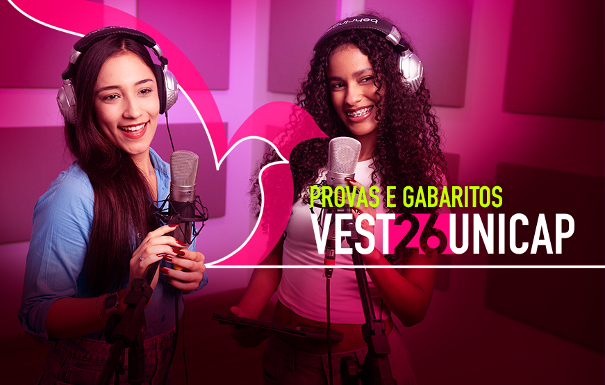A imagem é uma arte promocional retangular com fundo roxo escuro e painéis acústicos na parede, parecendo um estúdio de gravação. No centro, duas jovens mulheres sorridentes usam fones de ouvido grandes prateados. À esquerda: moça de cabelo liso longo preto, pele clara, blusa azul clara, segura um microfone profissional com a mão direita (unhas vermelhas escuras) e usa relógio no pulso esquerdo. À direita: moça de cabelo cacheado volumoso preto, pele morena, sorriso com aparelho nos dentes, blusa branca, segura outro microfone e um tablet/celular na mão esquerda. Sobre a imagem, elementos gráficos rosa e uma onda estilizada à esquerda. No centro-direita, texto em letras maiúsculas: PROVAS E GABARITOS em verde neon, logo abaixo VEST26UNICAP bem grande (com o 26 em rosa) e uma linha branca fina embaixo. A imagem promove conteúdo sobre as provas e gabaritos do Vestibular Unicap 2026 da Universidade Católica de Pernambuco.