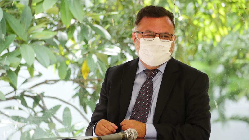 Imagem de Padre Pedro de máscara, no salão receptivo, respeitando distanciamento social imposto pela pandemia